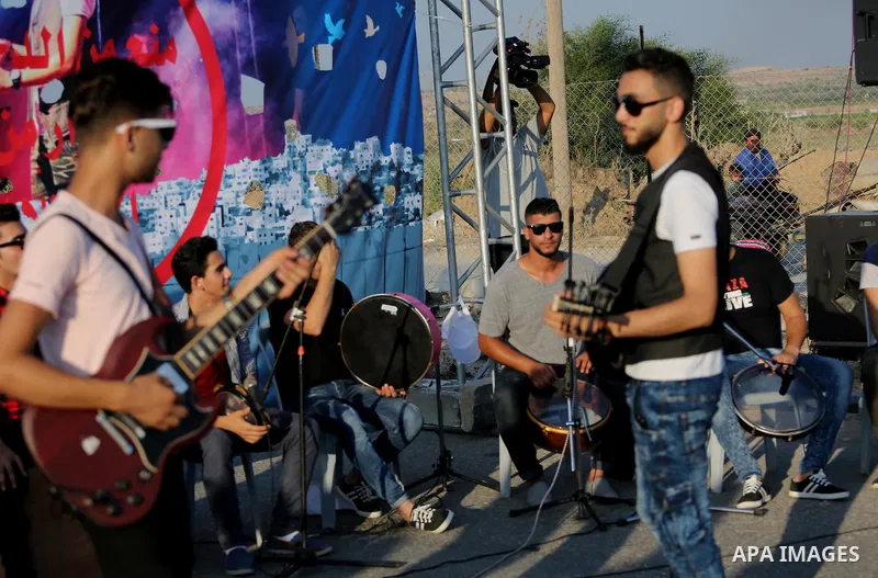 Palestinian band Dawaween, who were denied access to perform at a festival in Jerusalem, deliver a performance as part of a protest against the denial in Beit Hanun, near the Erez crossing point with Israel, in the north...