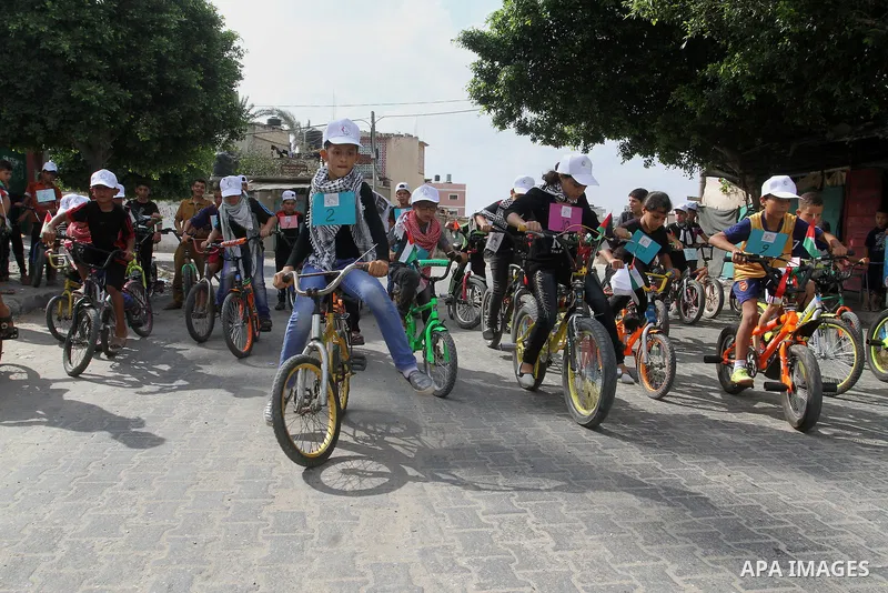 Palestinian children take part in the bicycles marathon to demand their right to play and break the siege on Gaza strip, in Rafah in the southern Gaza Strip. on August 7, 2016. Photo by Abed Rahim Khatib