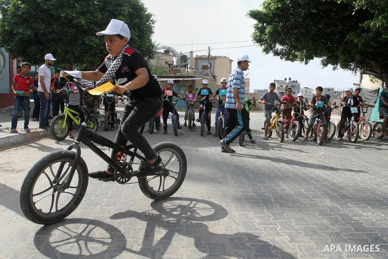 Palestinian children take part in the bicycles marathon to demand their right to play and break the siege on Gaza strip, in Rafah in the southern Gaza Strip. on August 7, 2016. Photo by Abed Rahim Khatib