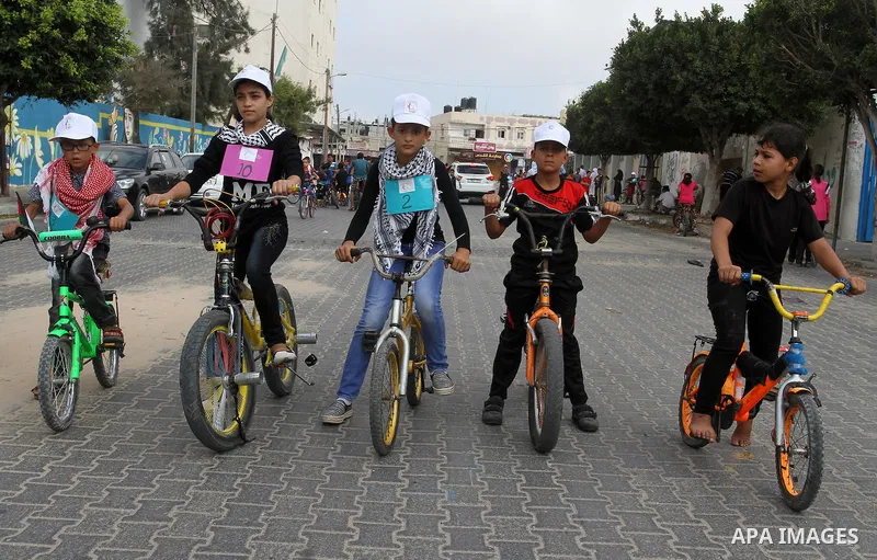 Palestinian children take part in the bicycles marathon to demand their right to play and break the siege on Gaza strip, in Rafah in the southern Gaza Strip. on August 7, 2016. Photo by Abed Rahim Khatib