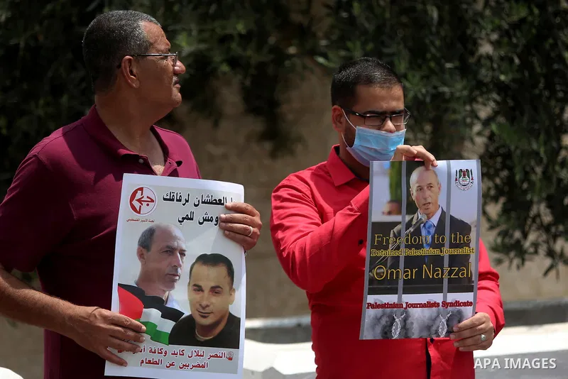 Palestinians take part during a protest calling for the release of Palestinian journalist Omar Nazzal and Bilal Kayed a Palestinian prisoner on hunger strike, in front of UN headquarters in the West Bank city of Ramallah...