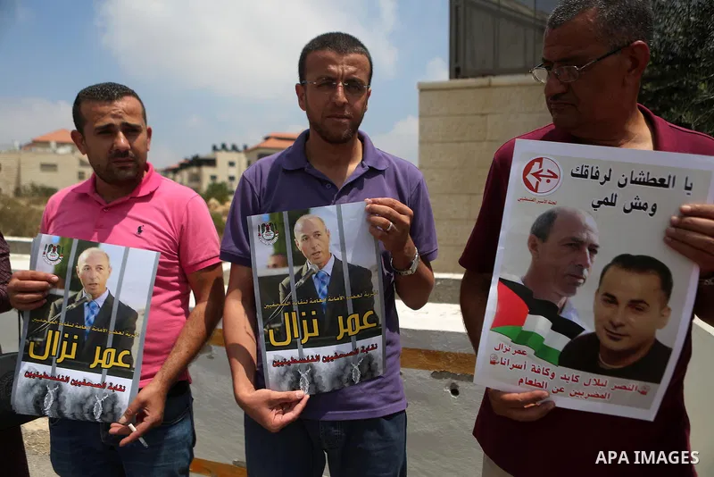 Palestinians take part during a protest calling for the release of Palestinian journalist Omar Nazzal and Bilal Kayed a Palestinian prisoner on hunger strike, in front of UN headquarters in the West Bank city of Ramallah...