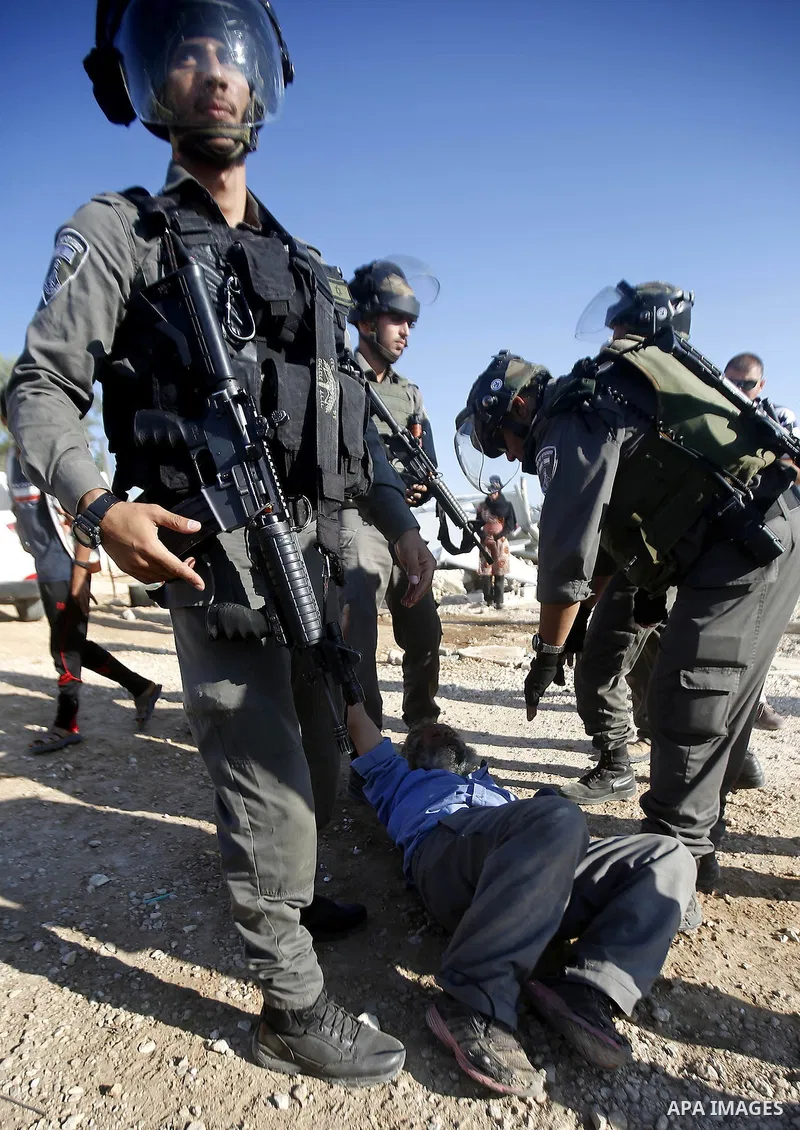 Israeli border policemen carry away a Palestinian man after Israeli troops demolished his shed near the West Bank village of Um AlKhair, south of Hebron August 9, 2016. Photo by Wisam Hashlamoun
