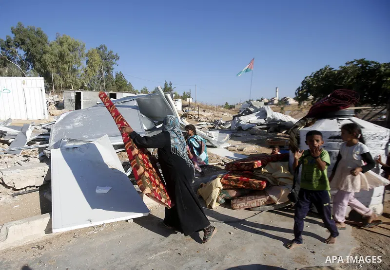Palestinians check their belongings after Israeli troops demolished their shed near the West Bank village of Um AlKhair, south of Hebron August 9, 2016. Photo by Wisam Hashlamoun