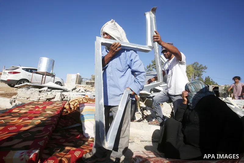 Palestinians check their belongings after Israeli troops demolished their shed near the West Bank village of Um AlKhair, south of Hebron August 9, 2016. Photo by Wisam Hashlamoun