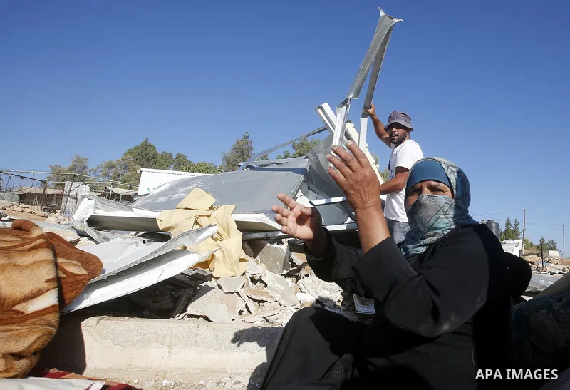Palestinians check their belongings after Israeli troops demolished their shed near the West Bank village of Um AlKhair, south of Hebron August 9, 2016. Photo by Wisam Hashlamoun