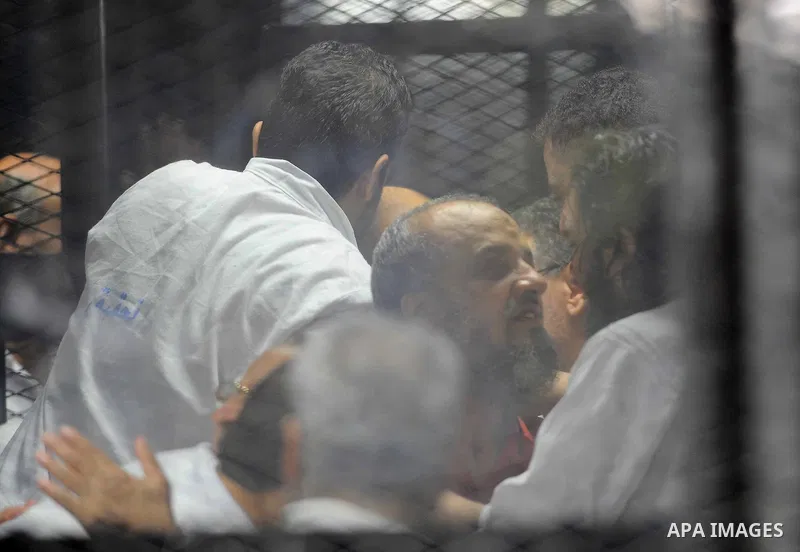 Egyptian Muslim Brotherhood defendants are seen behind bars during their trial, in a case known in media as "Rabaa Operations Room", in Cairo, on Aug. 09, 2016. Photo by Amr Sayed