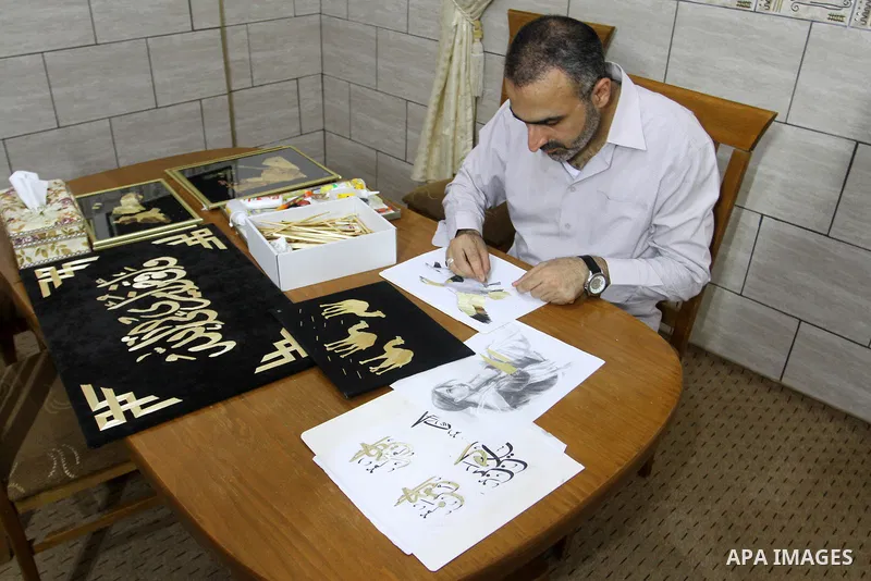 A Palestinian artist, Hossam Abed, fills the paintings from straw "wheat stalks", at his house, in Rafah in the southern Gaza strip, on August 10, 2016. Photo by Abed Rahim Khatib