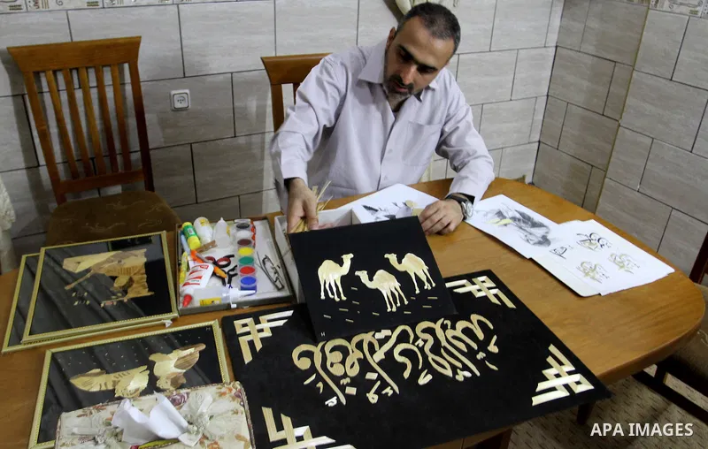 A Palestinian artist, Hossam Abed, fills the paintings from straw "wheat stalks", at his house, in Rafah in the southern Gaza strip, on August 10, 2016. Photo by Abed Rahim Khatib