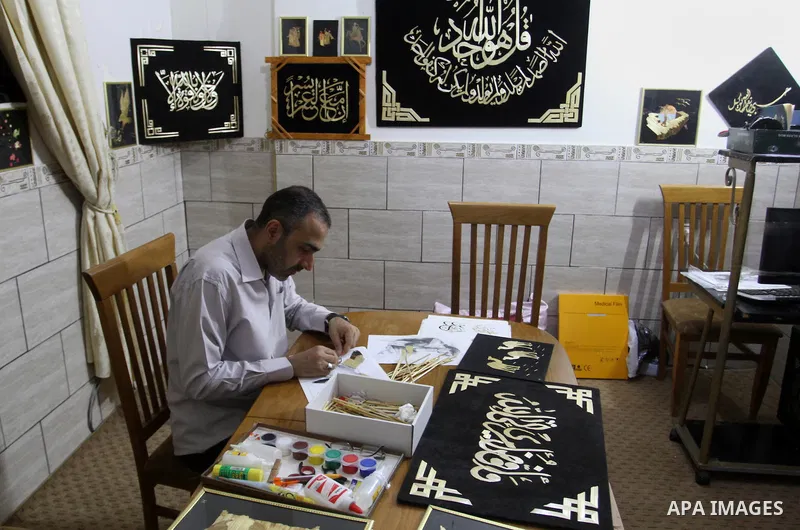 A Palestinian artist, Hossam Abed, fills the paintings from straw "wheat stalks", at his house, in Rafah in the southern Gaza strip, on August 10, 2016. Photo by Abed Rahim Khatib
