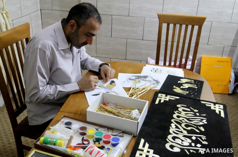 A Palestinian artist, Hossam Abed, fills the paintings from straw "wheat stalks", at his house, in Rafah in the southern Gaza strip, on August 10, 2016. Photo by Abed Rahim Khatib