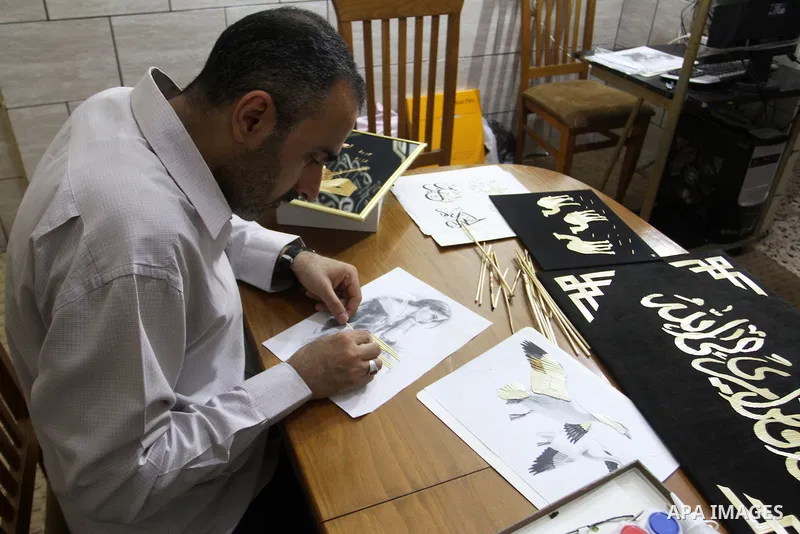 A Palestinian artist, Hossam Abed, fills the paintings from straw "wheat stalks", at his house, in Rafah in the southern Gaza strip, on August 10, 2016. Photo by Abed Rahim Khatib