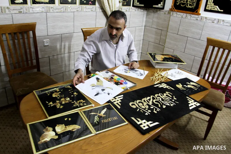 A Palestinian artist, Hossam Abed, fills the paintings from straw "wheat stalks", at his house, in Rafah in the southern Gaza strip, on August 10, 2016. Photo by Abed Rahim Khatib