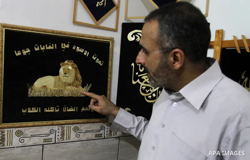 A Palestinian artist, Hossam Abed, fills the paintings from straw "wheat stalks", at his house, in Rafah in the southern Gaza strip, on August 10, 2016. Photo by Abed Rahim Khatib