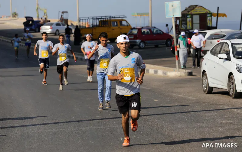 Palestinian youths take part in a marathon to mark the International Youth Day, in Gaza city, on Aug. 12, 2016. Photo by Mohammed Asad