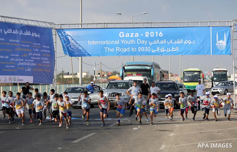 Palestinian children take part in a marathon to mark the International Youth Day, in Gaza city, on Aug. 12, 2016. Photo by Mohammed Asad