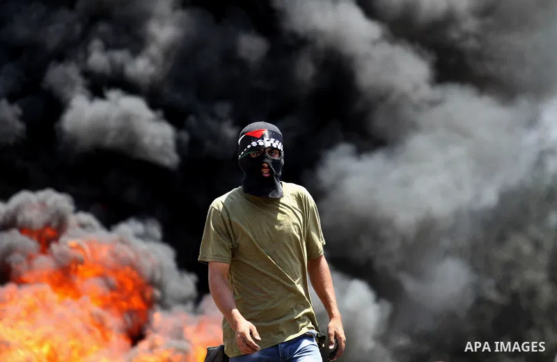 A Palestinian protester looks on during clashes with Israeli security forces following a weekly demonstration against the expropriation of Palestinian land by Israel on August 12, 2016, in the village of Kfar Qaddum, nea...