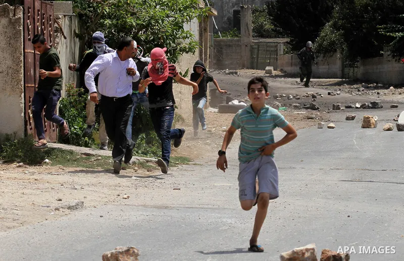 Palestinian protesters run during clashes with Israeli security forces following a weekly demonstration against the expropriation of Palestinian land by Israel on August 12, 2016, in the village of Kfar Qaddum, near Nabl...