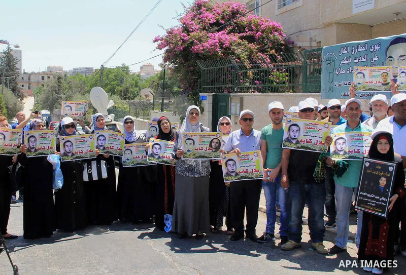 Palestinian protestors hold posters against administrative detention and in support of Palestinian prisoner Bilal Kayed (portrait), who has been fasting for almost two months over his detention without trial, as they dem...
