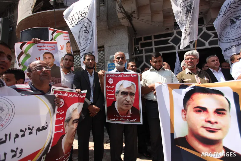 Palestinians hold posters against administrative detention and in support of Palestinian prisoner Bilal Kayed (portrait), who has been fasting for almost two months over his detention without trial, in Gaza city, on Augu...