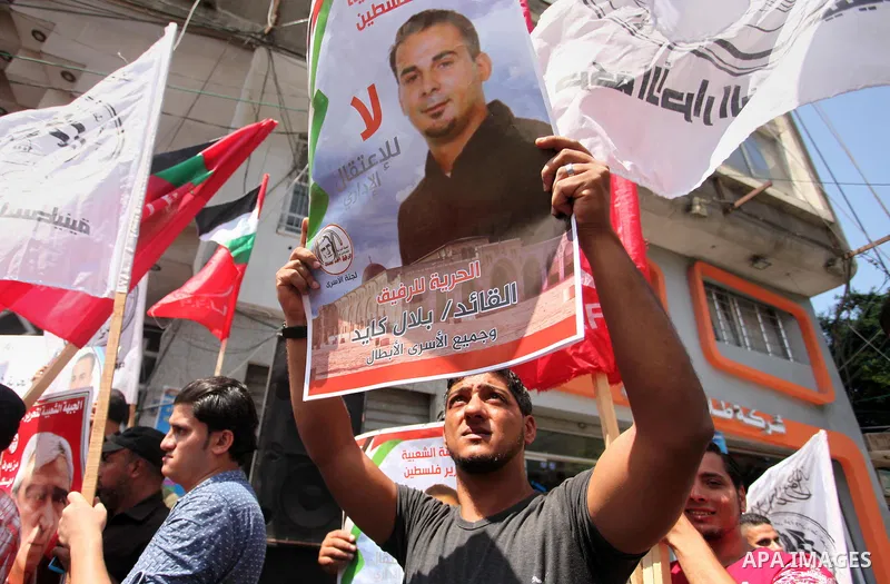 Palestinians hold posters against administrative detention and in support of Palestinian prisoner Bilal Kayed (portrait), who has been fasting for almost two months over his detention without trial, in Gaza city, on Augu...