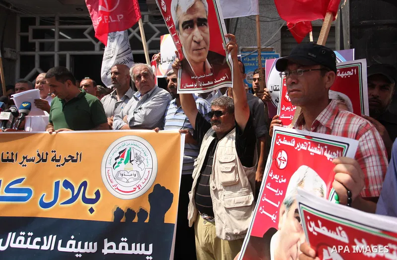 Palestinians hold posters against administrative detention and in support of Palestinian prisoner Bilal Kayed (portrait), who has been fasting for almost two months over his detention without trial, in Gaza city, on Augu...