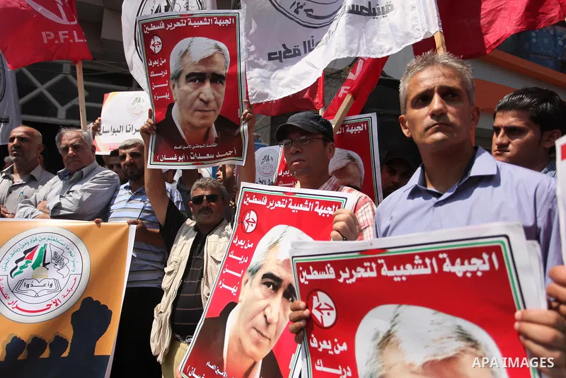 Palestinians hold posters against administrative detention and in support of Palestinian prisoner Bilal Kayed (portrait), who has been fasting for almost two months over his detention without trial, in Gaza city, on Augu...