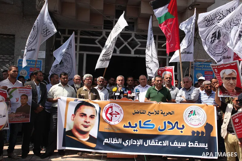 Palestinians hold posters against administrative detention and in support of Palestinian prisoner Bilal Kayed (portrait), who has been fasting for almost two months over his detention without trial, in Gaza city, on Augu...