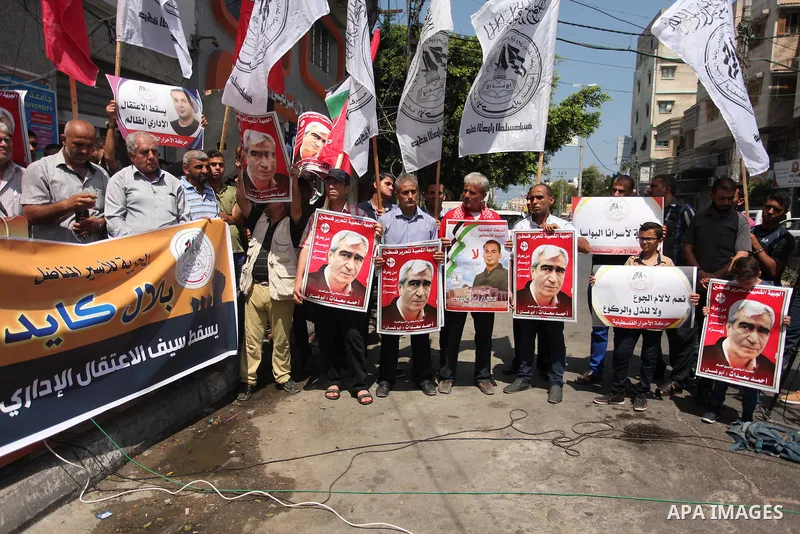 Palestinians hold posters against administrative detention and in support of Palestinian prisoner Bilal Kayed (portrait), who has been fasting for almost two months over his detention without trial, in Gaza city, on Augu...