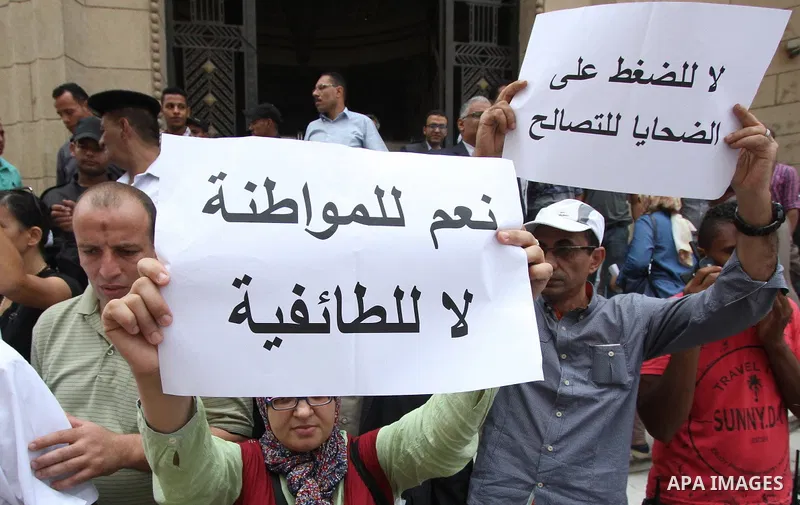 Egyptian Christians hold banners during a protest against Copts in Minya, in front of the High Court in Cairo, Egypt, on August 13, 2016. Photo by Amr Sayed
