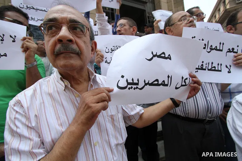 Egyptian Christians hold banners during a protest against Copts in Minya, in front of the High Court in Cairo, Egypt, on August 13, 2016. Photo by Amr Sayed