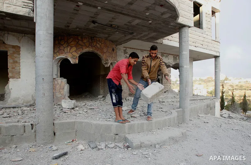 Relatives check the damage to the family house of Palestinian assailant Mohammad Tarayra after it was partially blown up by Israeli troops in the West Bank village of Bani Naem, east of Hebron August 15, 2016. Photo by W...