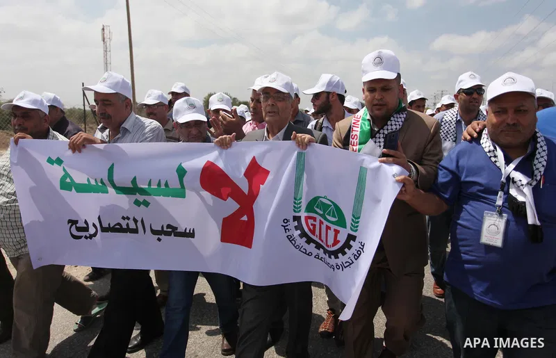 Palestinian traders hold banners during a protest against the Israeli authorities to withdraw permits for some of the traders and to prevent their entry into the West Bank, in front of the Erez crossing point with Israel...