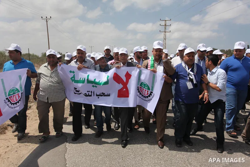 Palestinian traders hold banners during a protest against the Israeli authorities to withdraw permits for some of the traders and to prevent their entry into the West Bank, in front of the Erez crossing point with Israel...