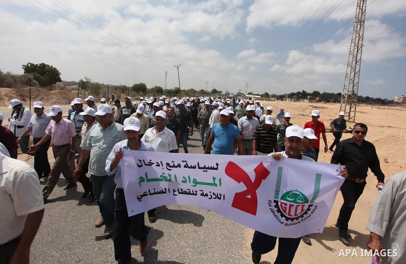 Palestinian traders hold banners during a protest against the Israeli authorities to withdraw permits for some of the traders and to prevent their entry into the West Bank, in front of the Erez crossing point with Israel...