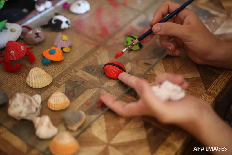 A Palestinian artist, Hanan El-ayoubi, 17, makes the art forms and decorations from seashells, at her house, on August 15, 2016. Photo by Mohammed Asad