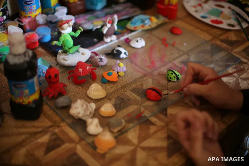 A Palestinian artist, Hanan El-ayoubi, 17, makes the art forms and decorations from seashells, at her house, on August 15, 2016. Photo by Mohammed Asad