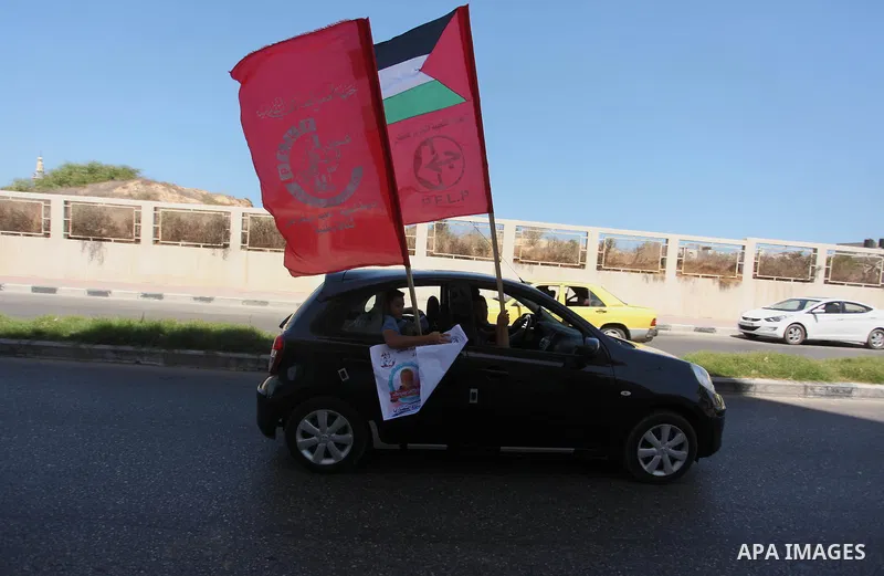 Palestinians hold posters against administrative detention and in support of Palestinian prisoner Bilal Kayed (portrait), who has been fasting for almost two months over his detention without trial, in Gaza city, on Augu...
