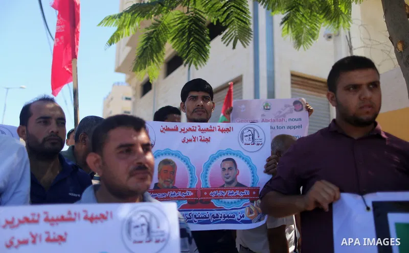 Palestinians hold posters against administrative detention and in support of Palestinian prisoner Bilal Kayed (portrait), who has been fasting for almost two months over his detention without trial, in Gaza city, on Augu...