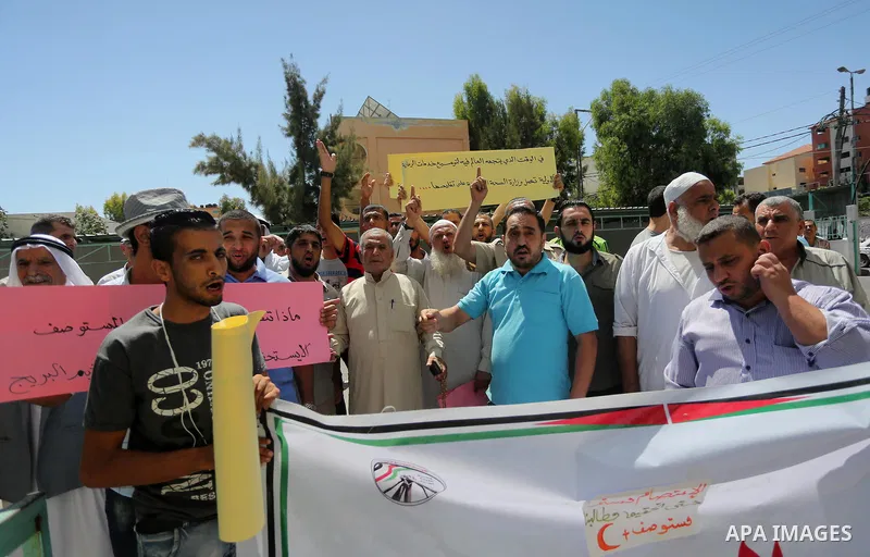 Palestinians from the Al-Bureij refugee camp, take part in protest demanding their rights, in Gaza city, on August 16, 2016. Photo by Mohammed Asad