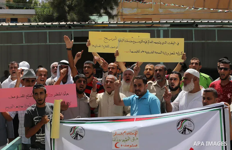 Palestinians from the Al-Bureij refugee camp, take part in protest demanding their rights, in Gaza city, on August 16, 2016. Photo by Mohammed Asad