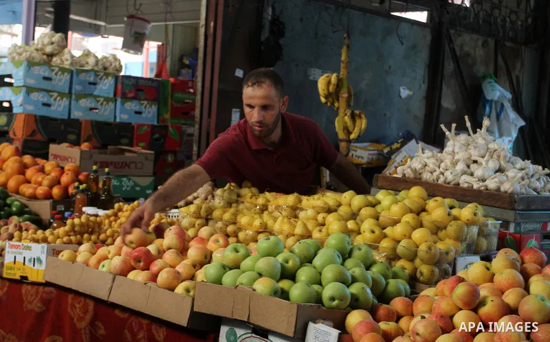 Palestinians shop at a market in Rafah in the southern Gaza strip, on August 16, 2016. Photo by Abed Rahim Khatib
