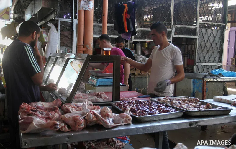 A Palestinian vendor sells meats at his shop in a market in Rafah in the southern Gaza strip, on August 16, 2016. Photo by Abed Rahim Khatib