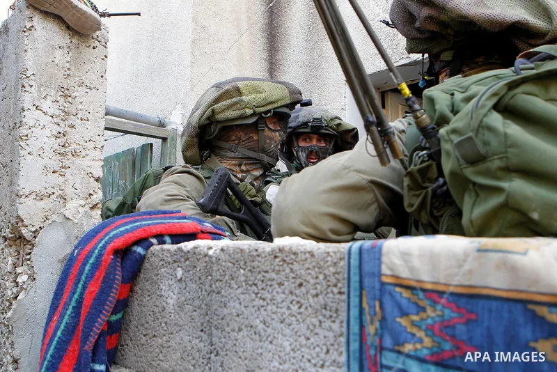 Israeli soldiers conduct searches in the Palestinian al-Fawwar refugee camp, south of the West Bank city of Hebron, on August 16, 2016. Twenty-five Palestinians were wounded in clashes with Israeli soldiers conducting se...