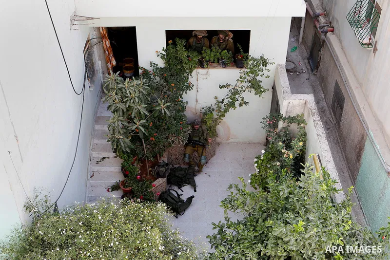 Israeli soldiers conduct searches in the Palestinian al-Fawwar refugee camp, south of the West Bank city of Hebron, on August 16, 2016. Twenty-five Palestinians were wounded in clashes with Israeli soldiers conducting se...