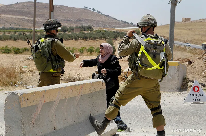 A Palestinian woman argues with Israeli soldiers as she is searched at an entrance of the al-Fawwar refugee camp, south of the West Bank city of Hebron, on August 16, 2016 as the Israeli army conducts searches in the cam...