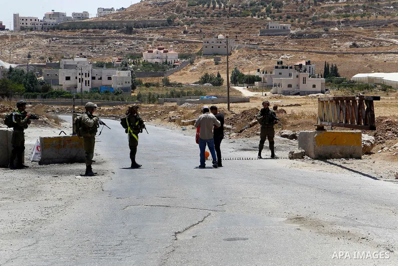 Israeli soldiers search Palestinian men at the main entrance of the Palestinian al-Fawwar refugee camp, south of the West Bank city of Hebron, on August 16, 2016 as the Israeli army conducts searches. Twenty-five Palesti...