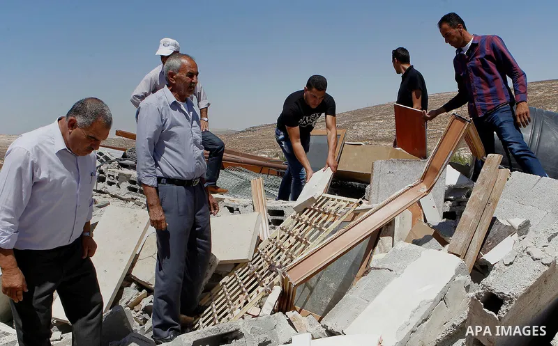 Palestinians check their belongings after Israeli troops demolished their house in the West Bank village of Saeer, near Hebron August 16, 2016. Photo by Wisam Hashlamoun