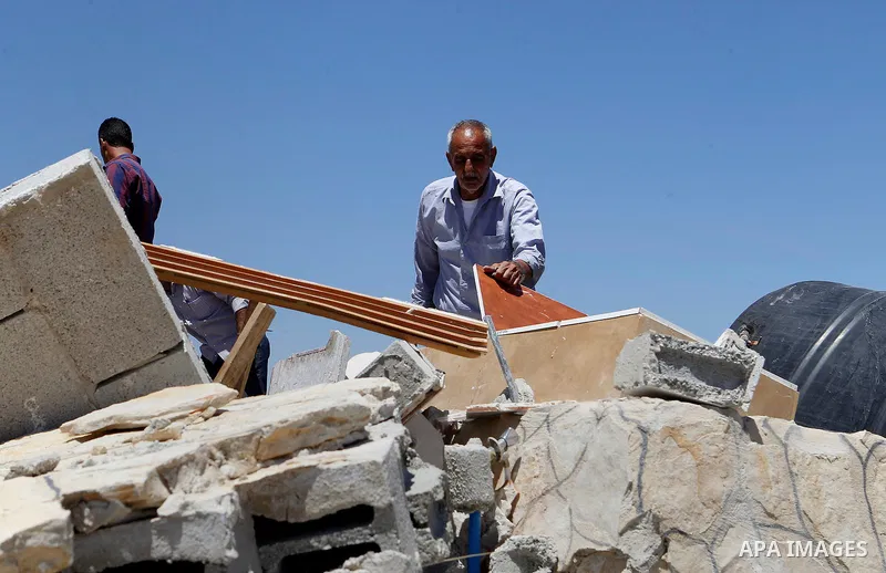 Palestinians check their belongings after Israeli troops demolished their house in the West Bank village of Saeer, near Hebron August 16, 2016. Photo by Wisam Hashlamoun