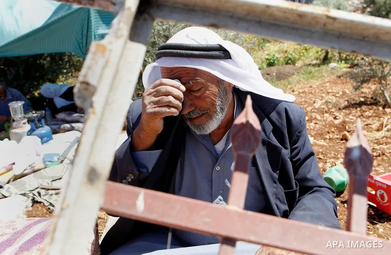 A Palestinian man reacts after Israeli troops demolished his house in the West Bank village of Saeer, near Hebron August 16, 2016. Photo by Wisam Hashlamoun